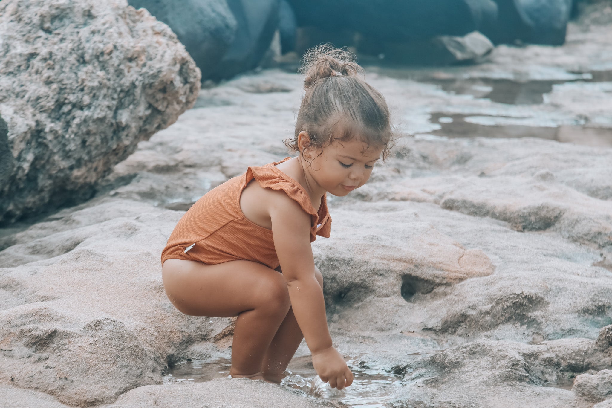 Children wearing KidORCA colorful swimwear at the beach by the shore