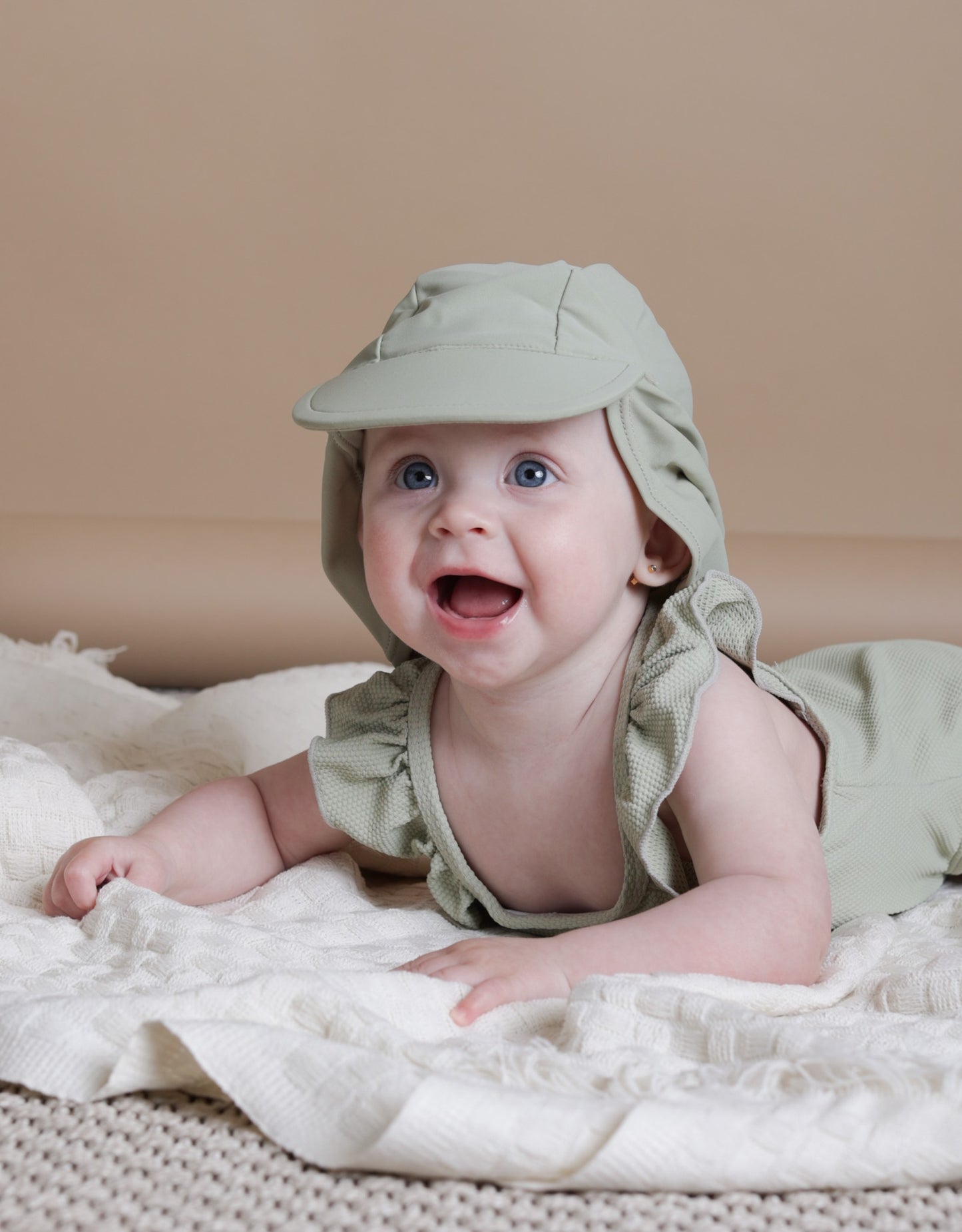 Girl playing in sage green waffle weave swimsuit by KidORCA