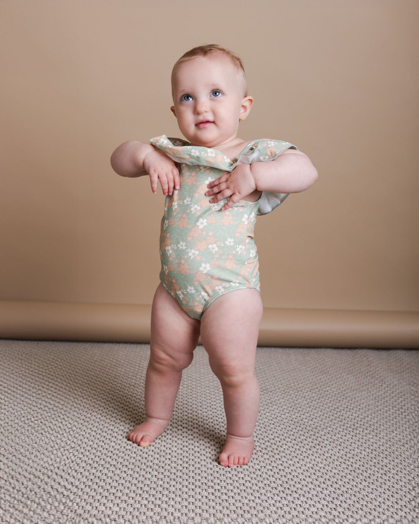 Girl playing in sage green ruffle swimsuit by KidORCA