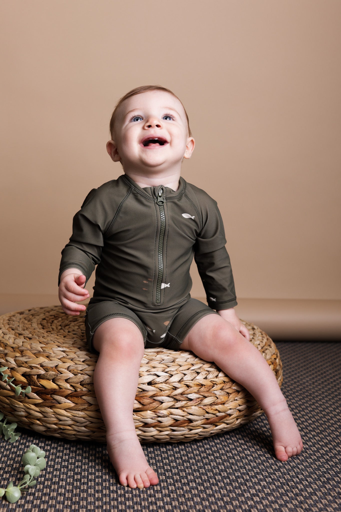 Baby playing in Trout Kalamata swim jumpsuit by KidORCA