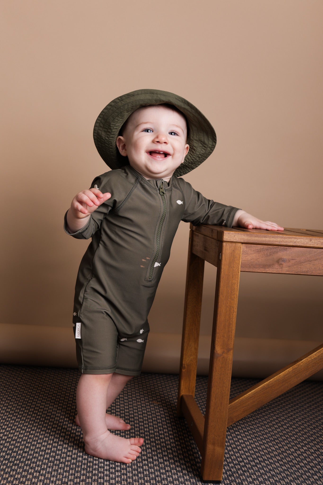 Baby wearing Trout Kalamata jumpsuit – side view with high collar