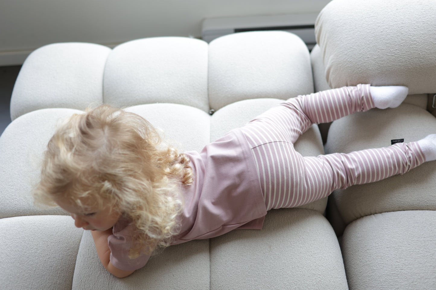 Kid playing in mauve striped extra‑long leggings by KidORCA