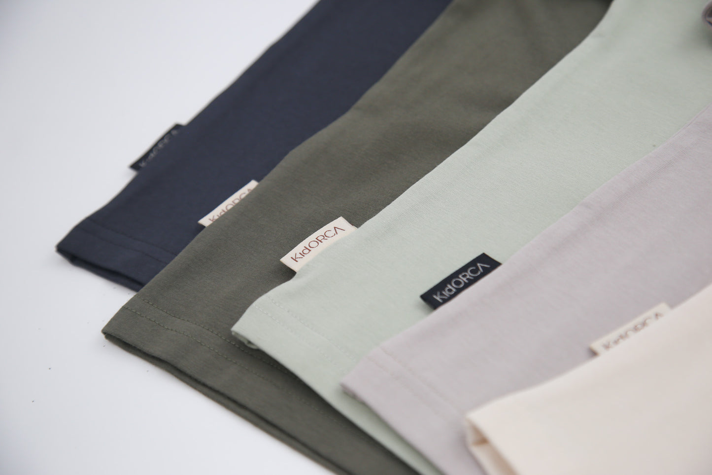 Close-up of organic cotton fabric on dusty olive kids tee