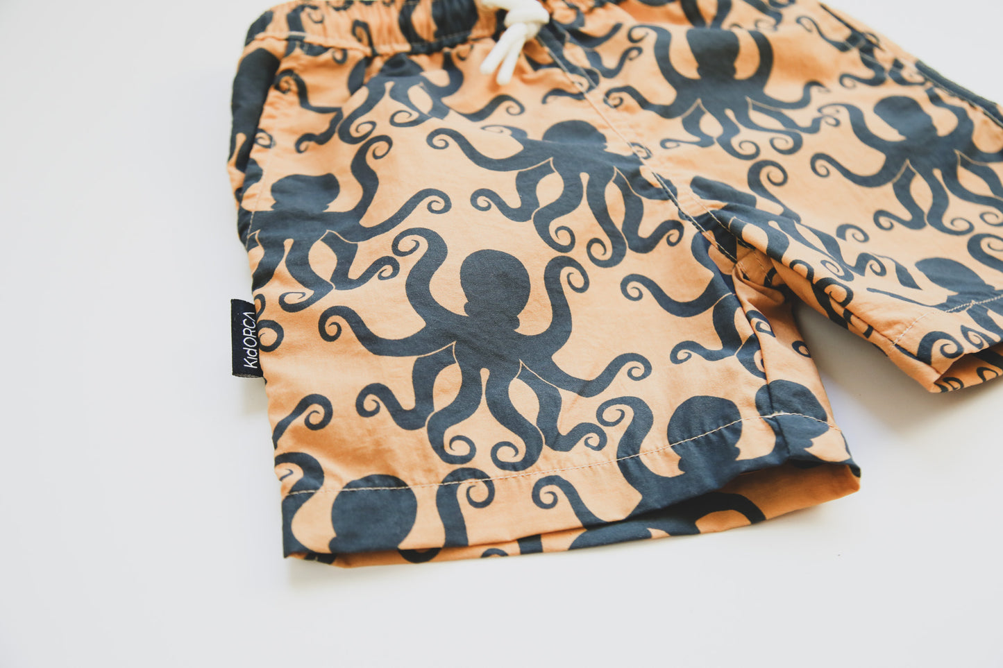 Close-up of quick-dry recycled polyester fabric – octopus desert sand swim trunks