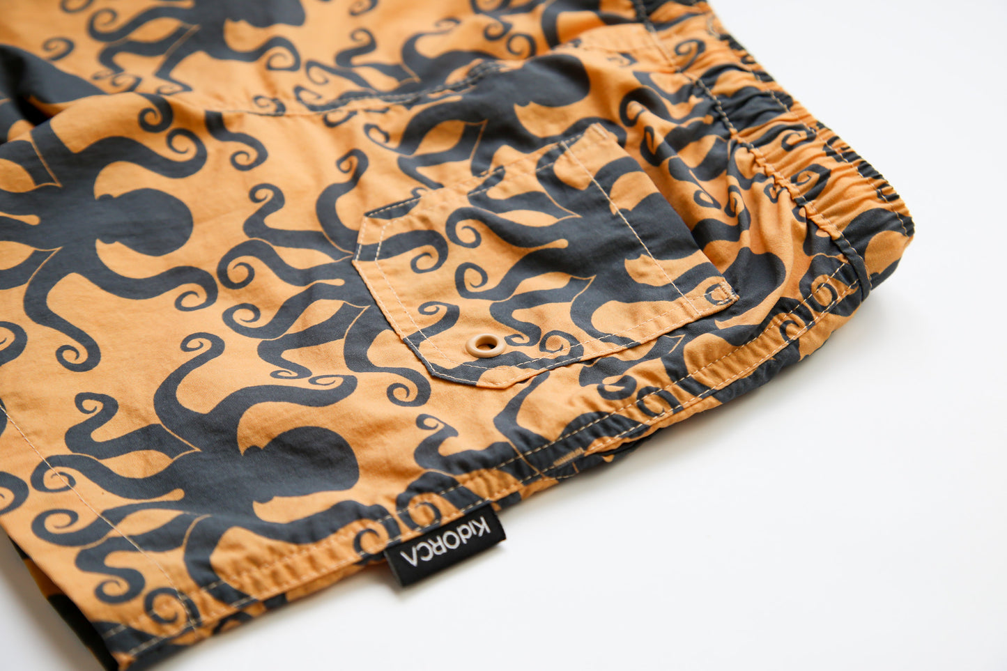 Close-up of quick-dry recycled polyester fabric – octopus desert sand swim trunks