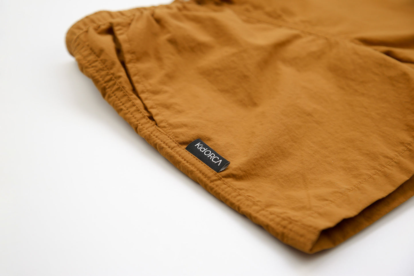 Close-up of quick-dry recycled polyester fabric – ginger swim trunks