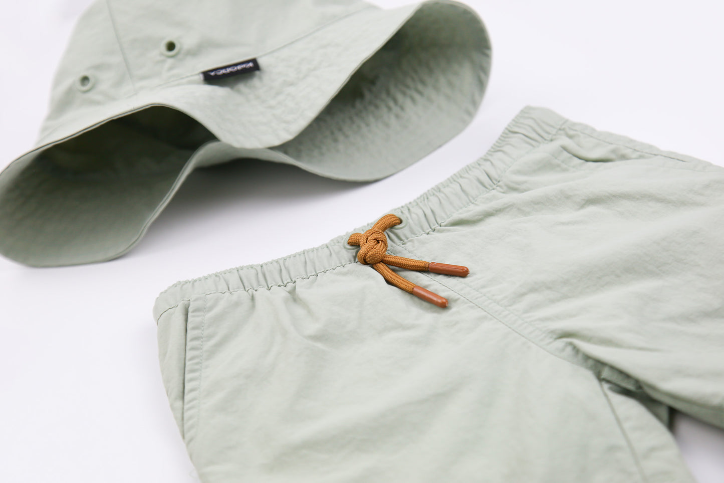 Close-up of quick-dry recycled polyester fabric – sage green swim trunks