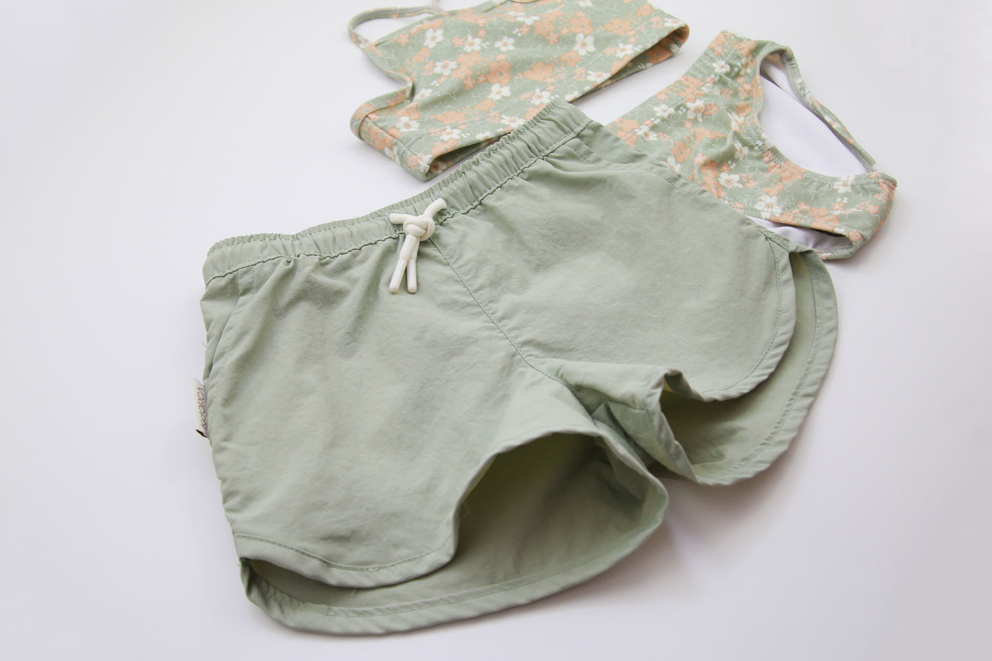 Close-up of quick-dry sage green fabric – girls swim trunks
