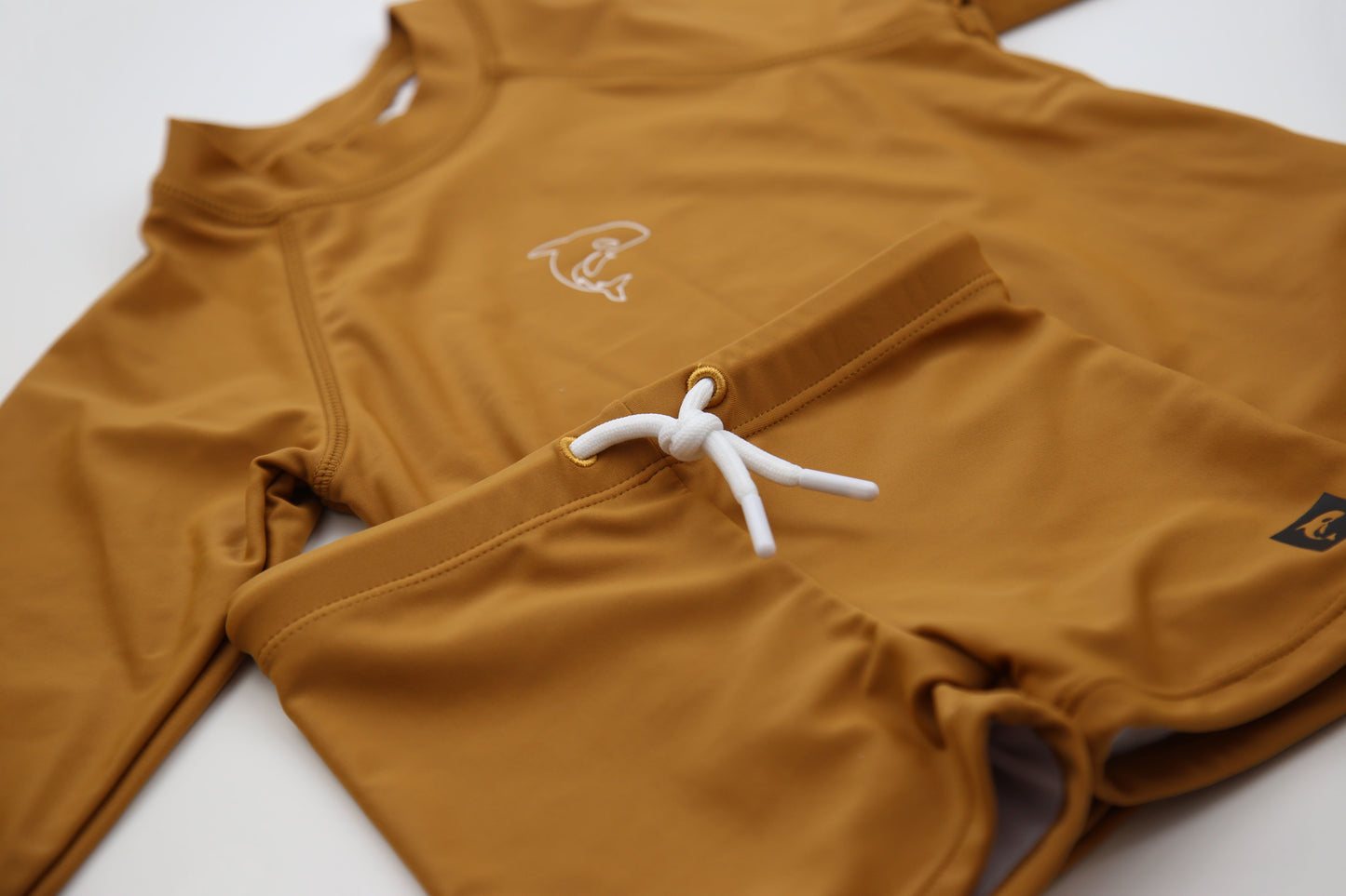 Close-up of UPF 50+ quick-dry recycled polyester fabric – ginger rashguard