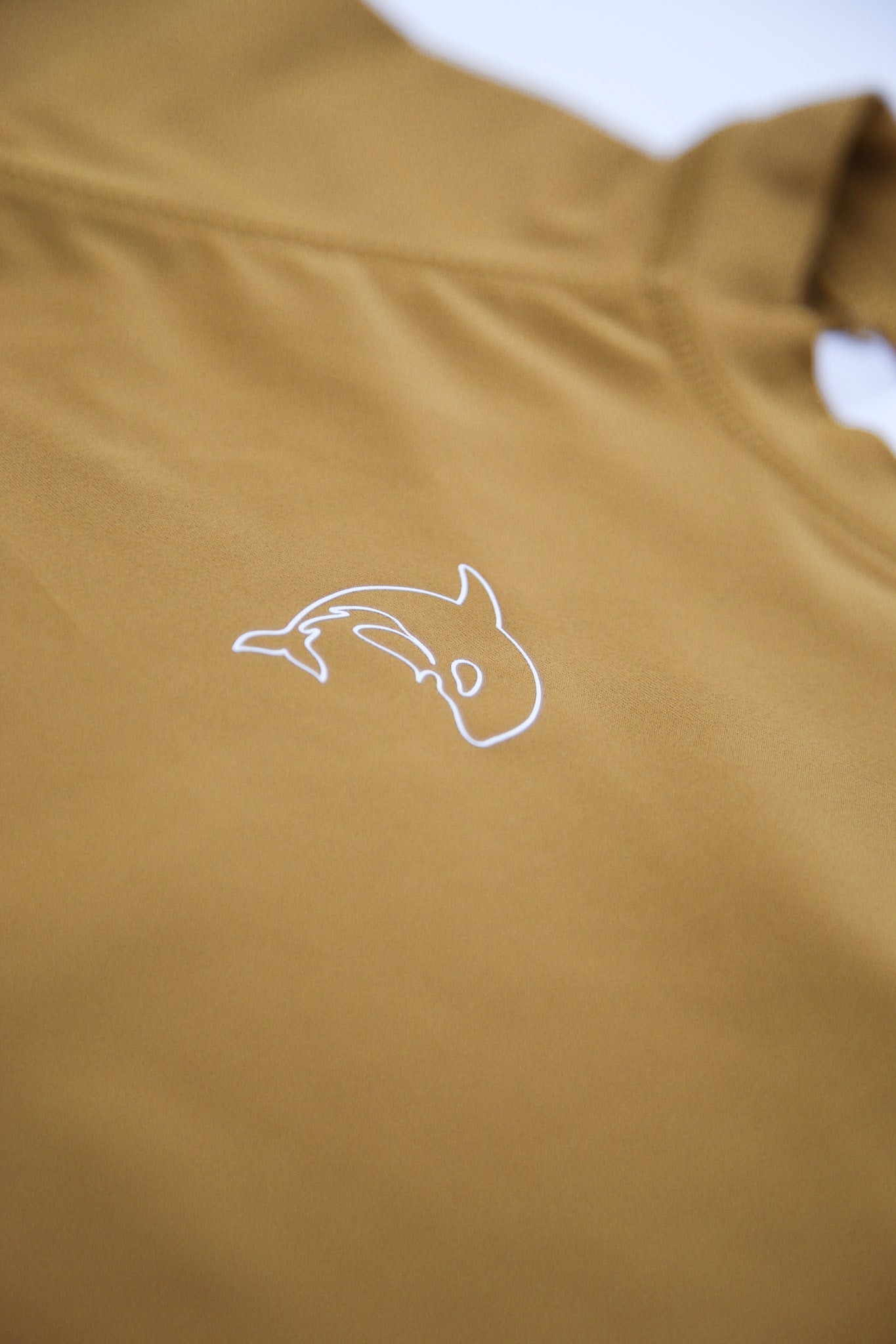Close-up of UPF 50+ quick-dry recycled polyester fabric – ginger rashguard