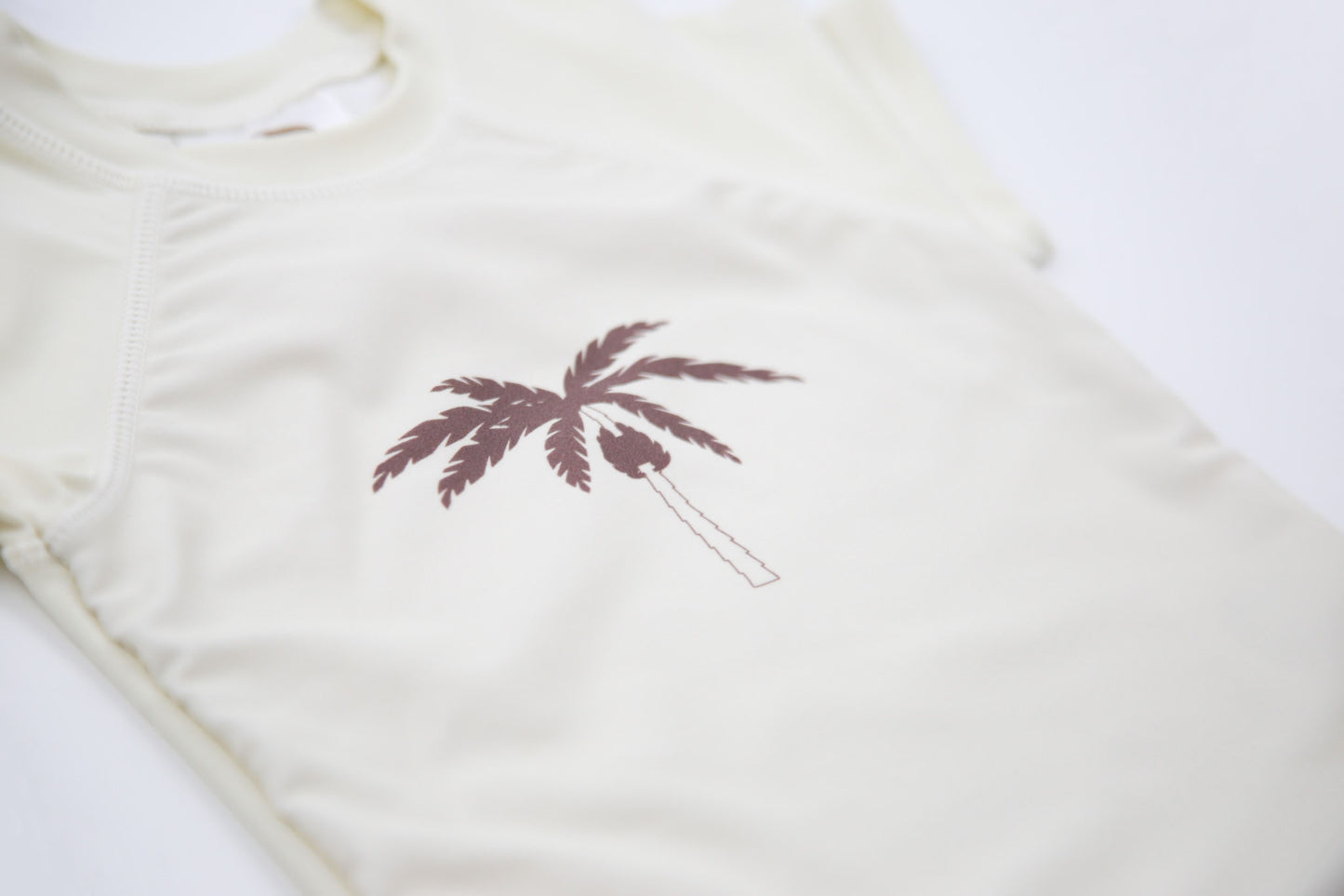 Close-up of UPF 50+ quick-dry recycled polyester – palm tree rashguard