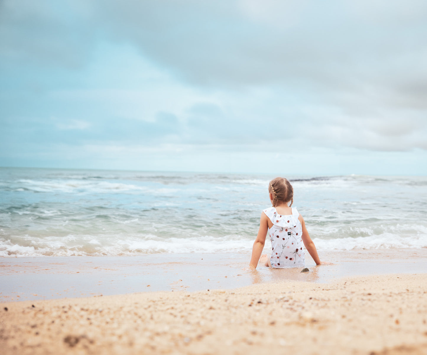 Girl playing in Lalliana coconut ruffle swimsuit by KidORCA