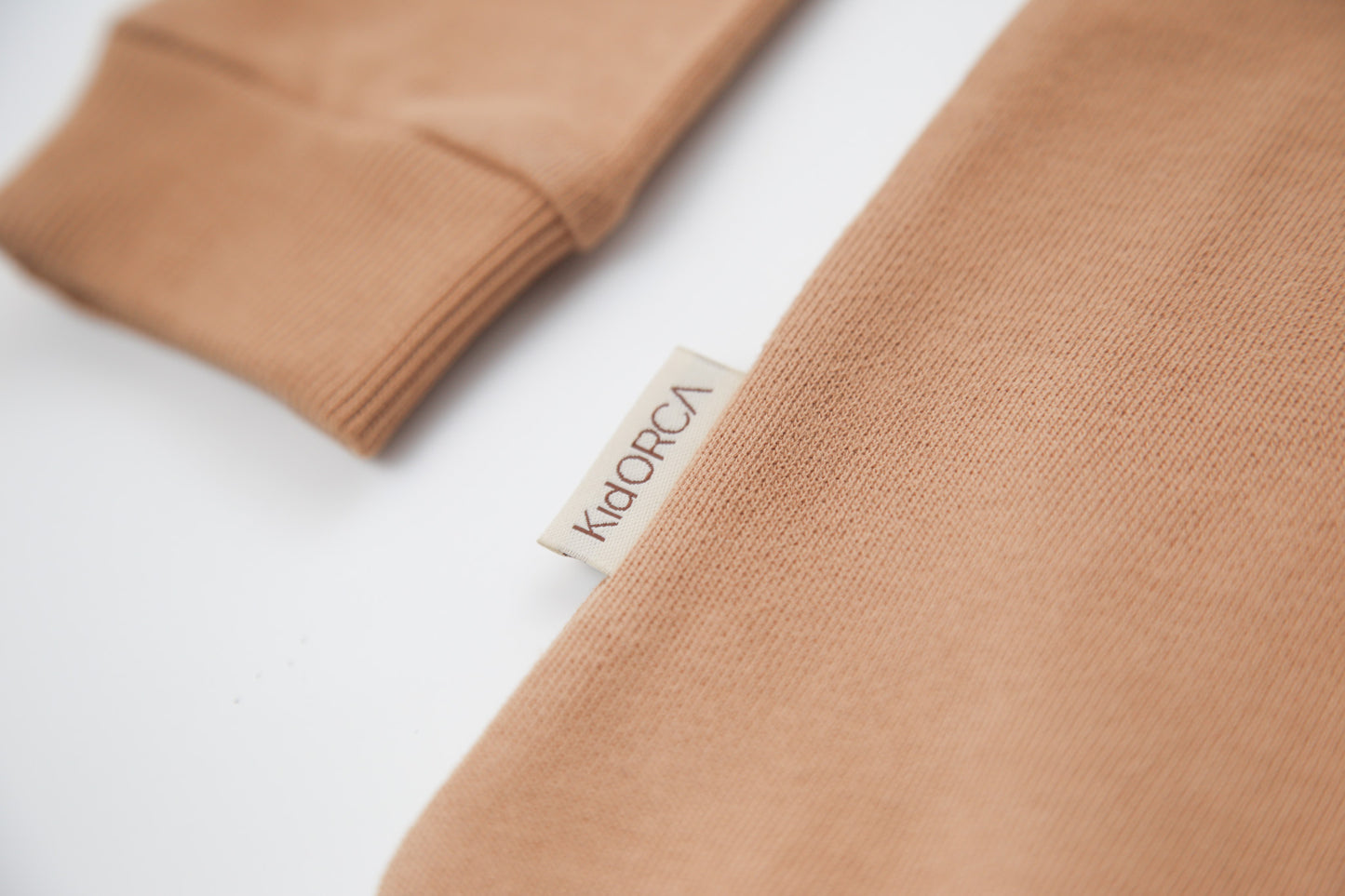 Close-up of soft organic french terry fabric texture – sandstone kids sweatshirt
