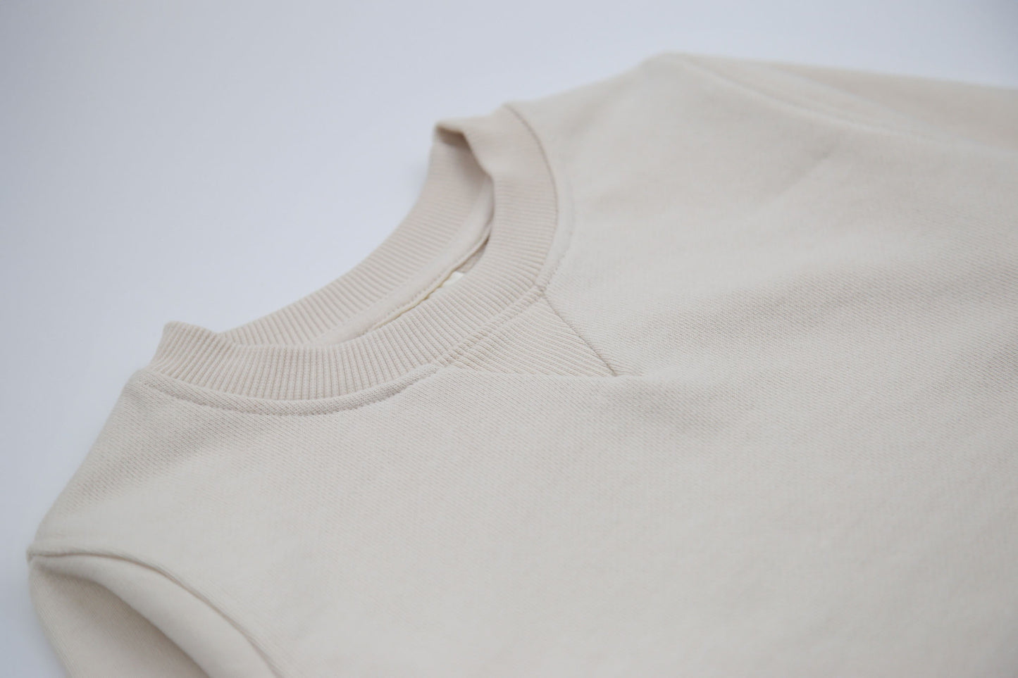 Close-up of french terry fabric and crewneck on oat kids sweatshirt