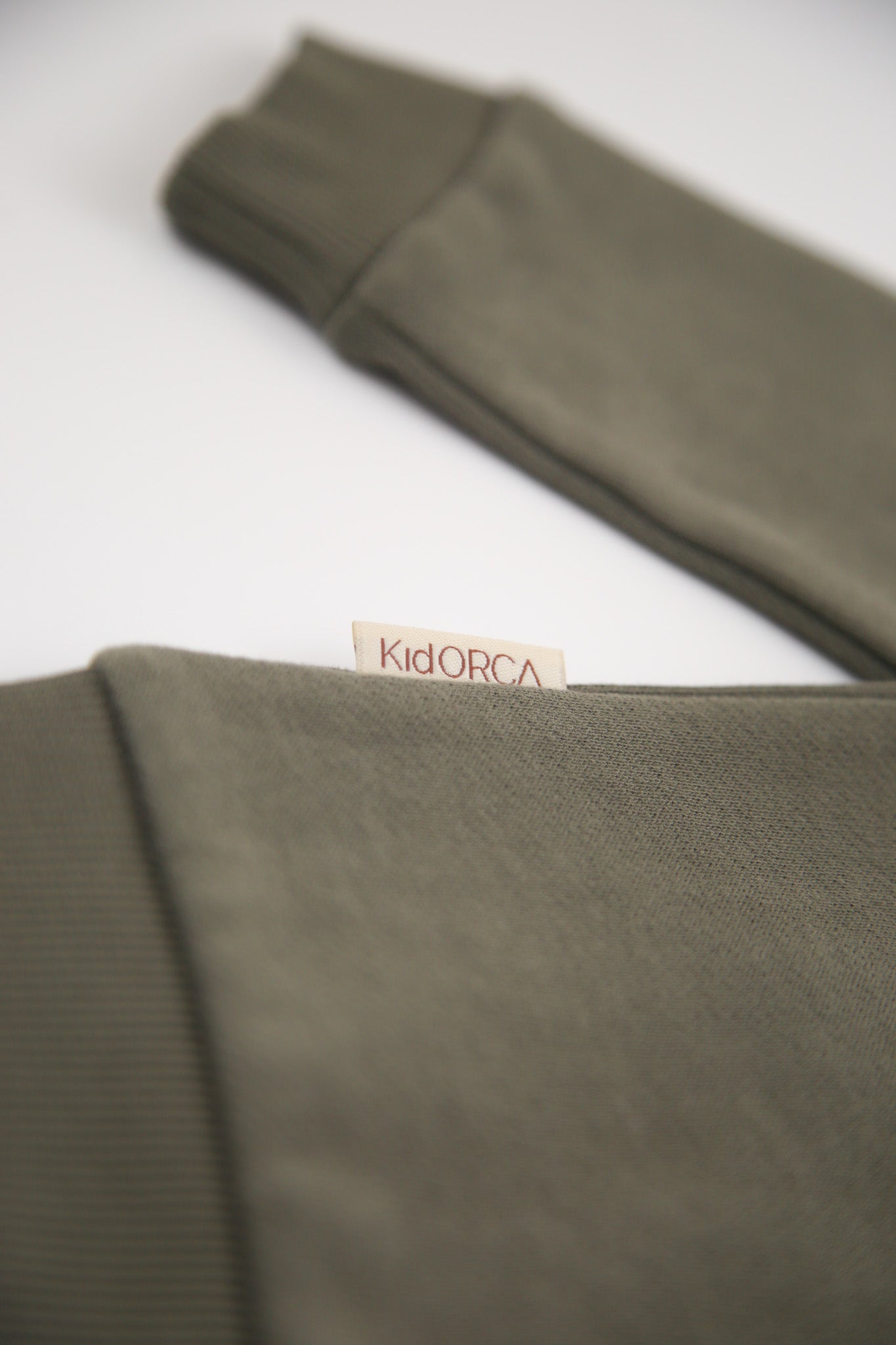 Rib cuff and hem detail on dusty olive french terry kids sweatshirt