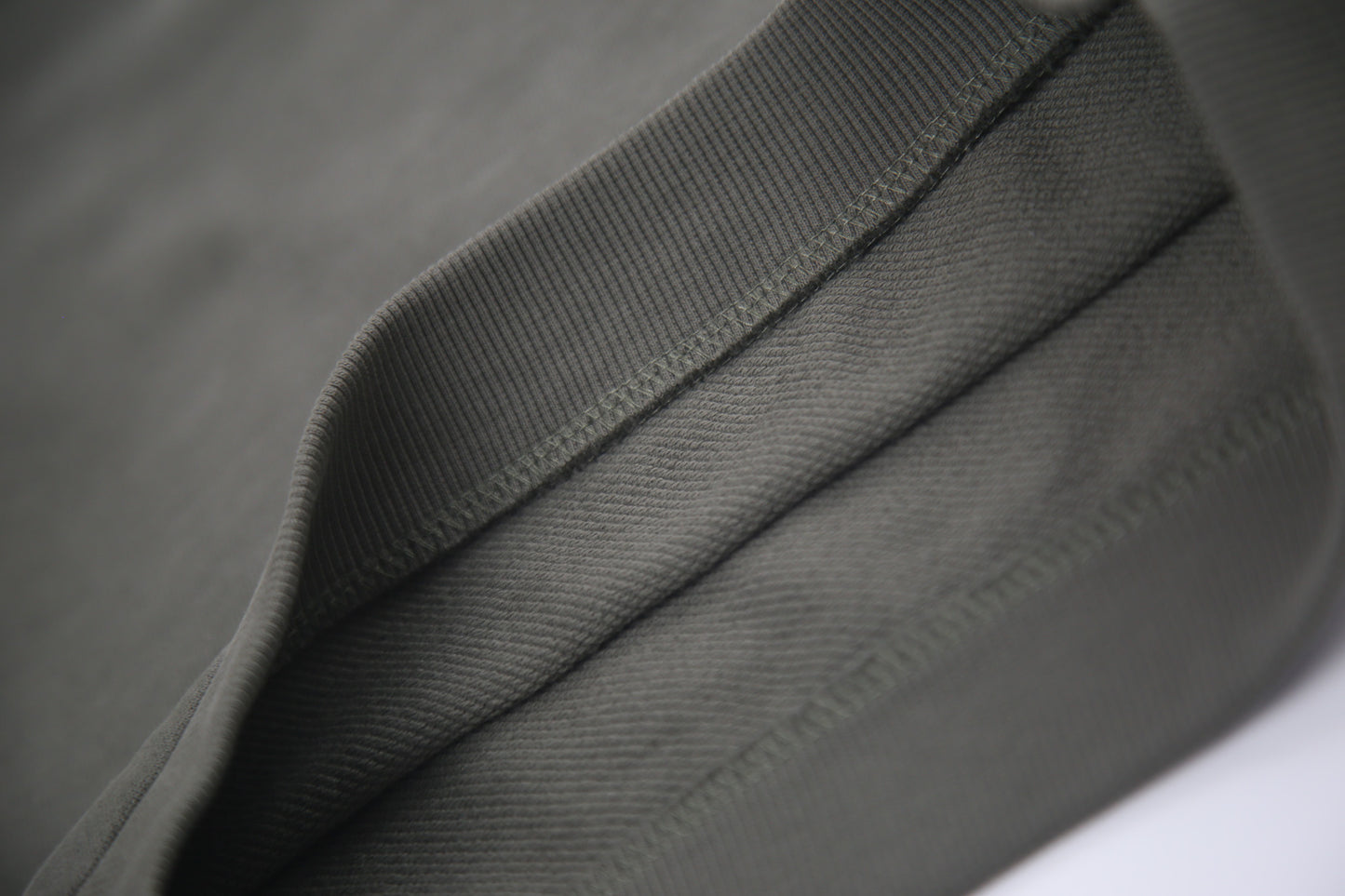 Close-up of french terry fabric and crewneck on dusty olive kids sweatshirt