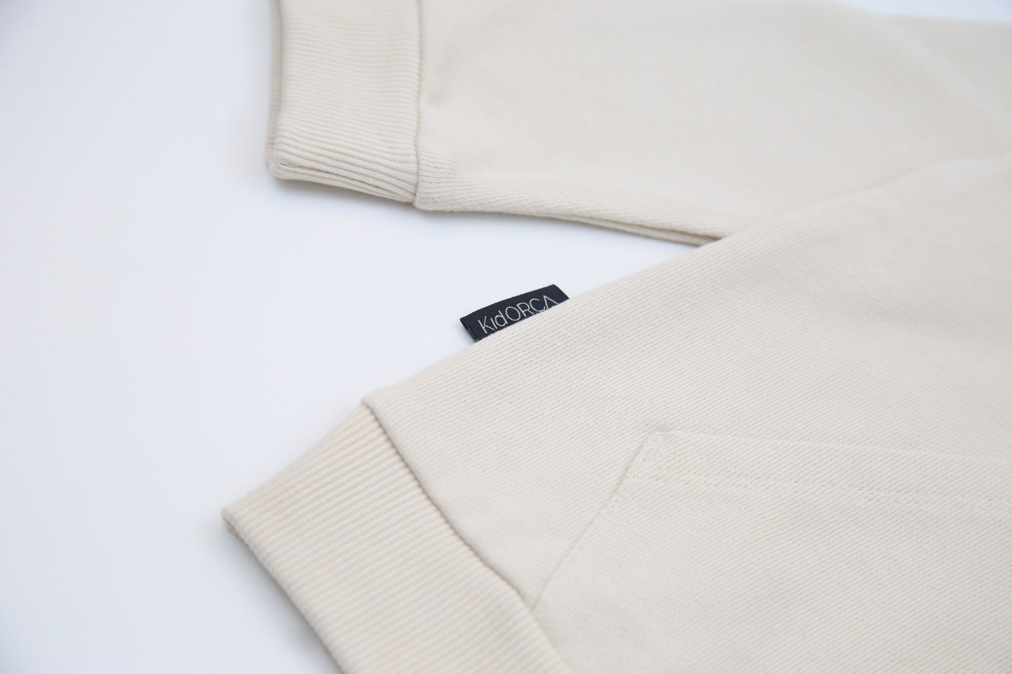 Kangaroo pocket and rib cuff detail on oat french terry kids hoodie