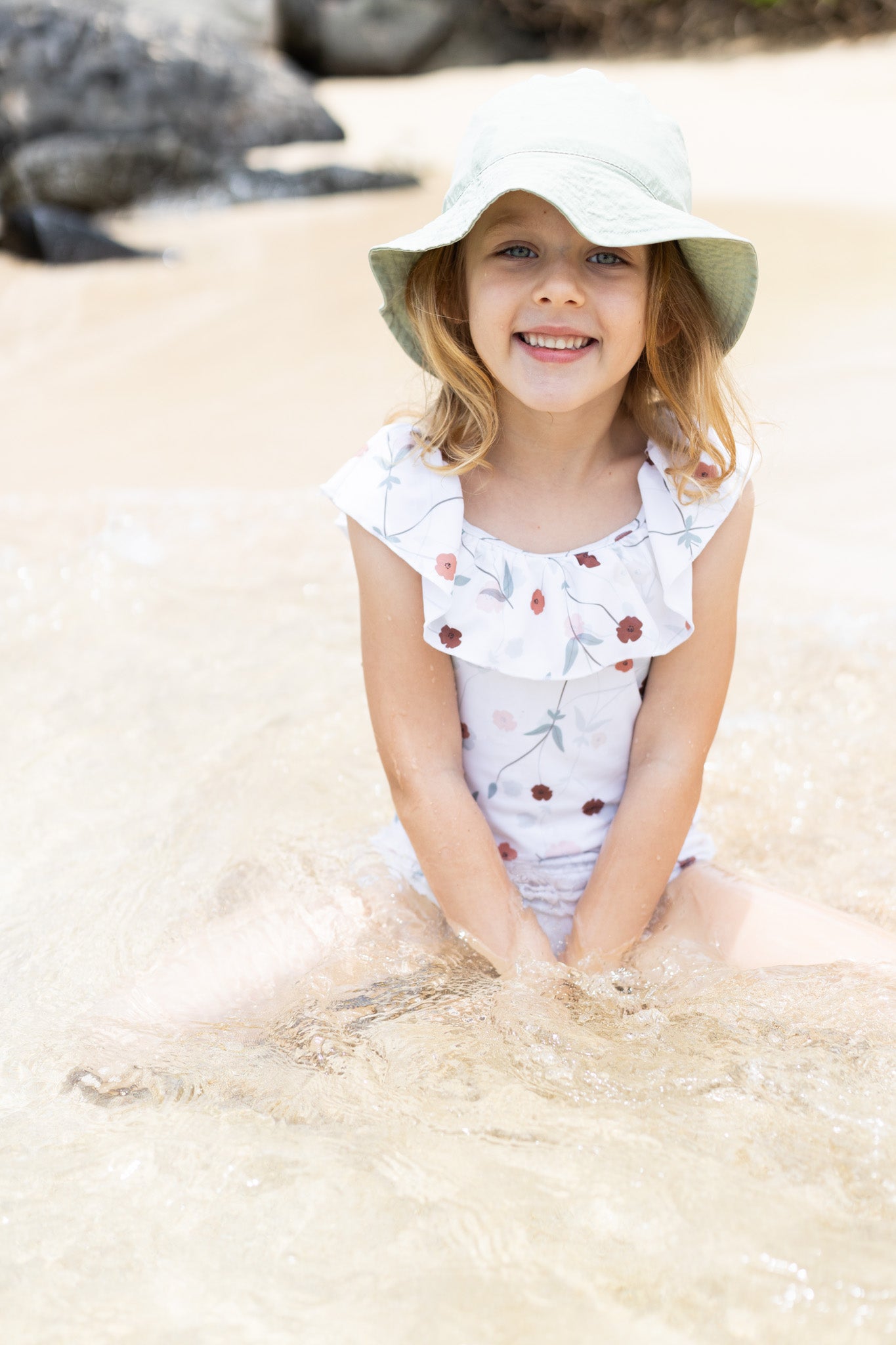 Girl playing in Lalliana coconut ruffle swimsuit by KidORCA