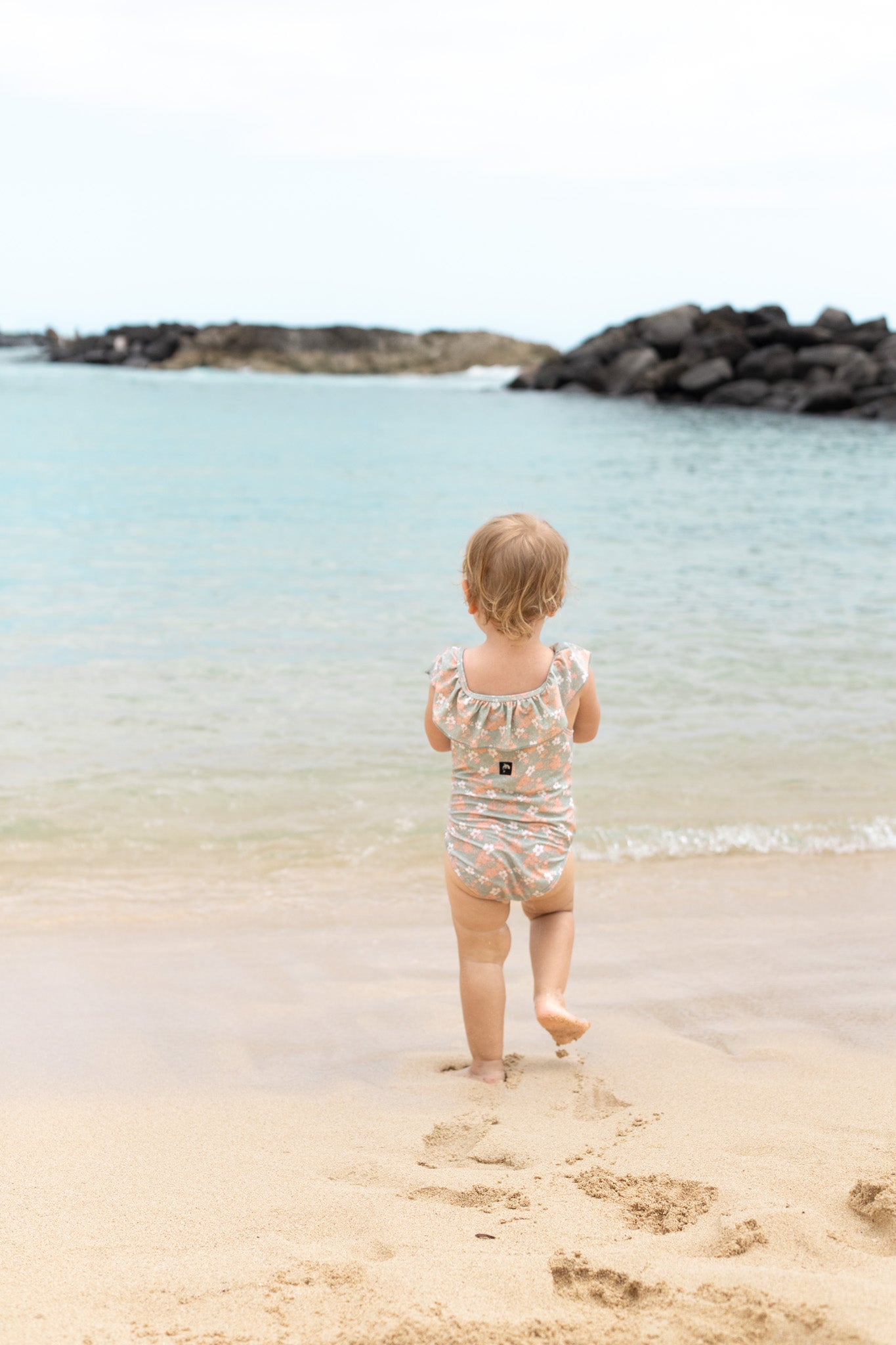 Girl playing in sage green ruffle swimsuit by KidORCA