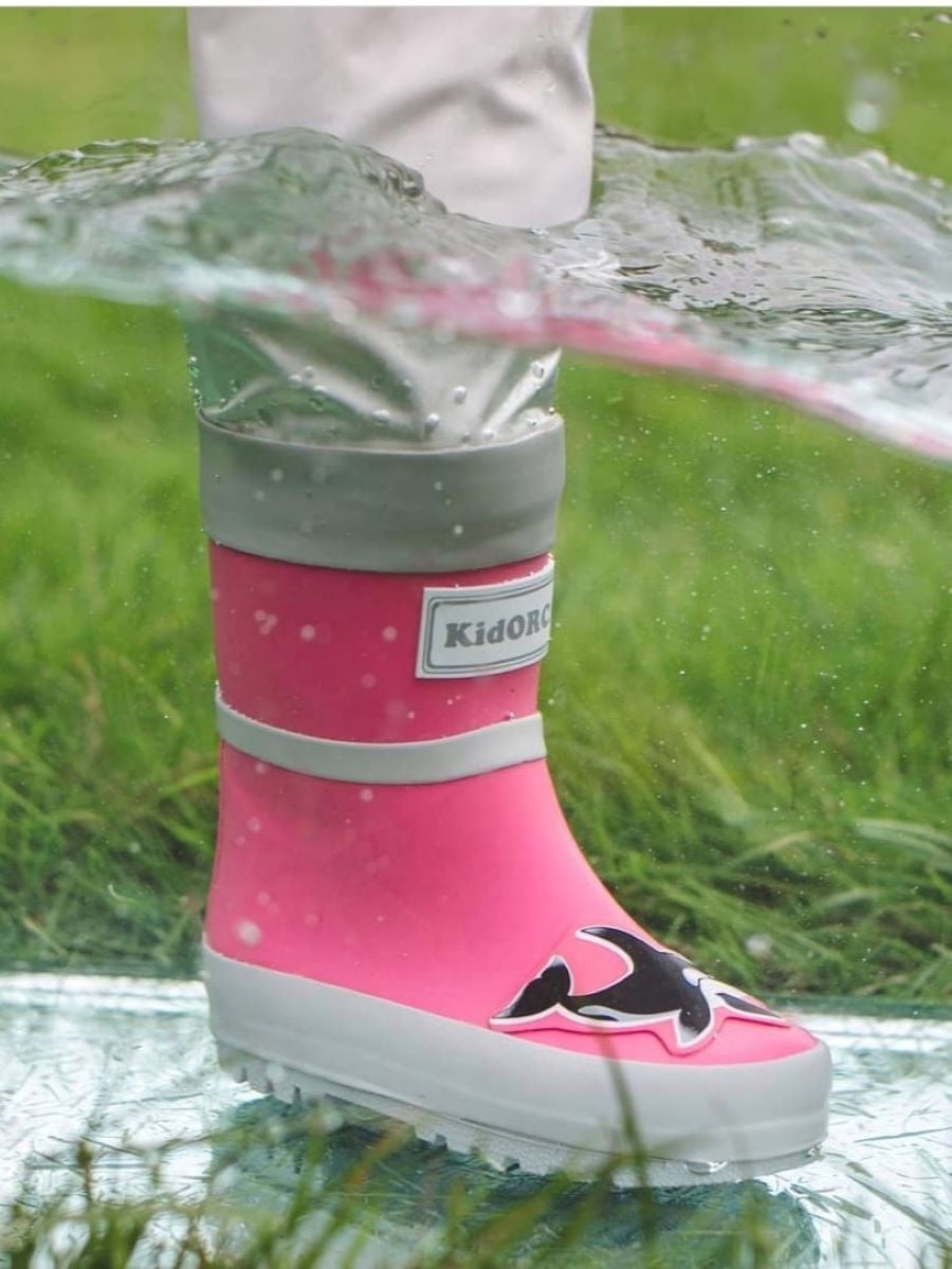 Child splashing in pink rain boots with above-knee waders by KidORCA
