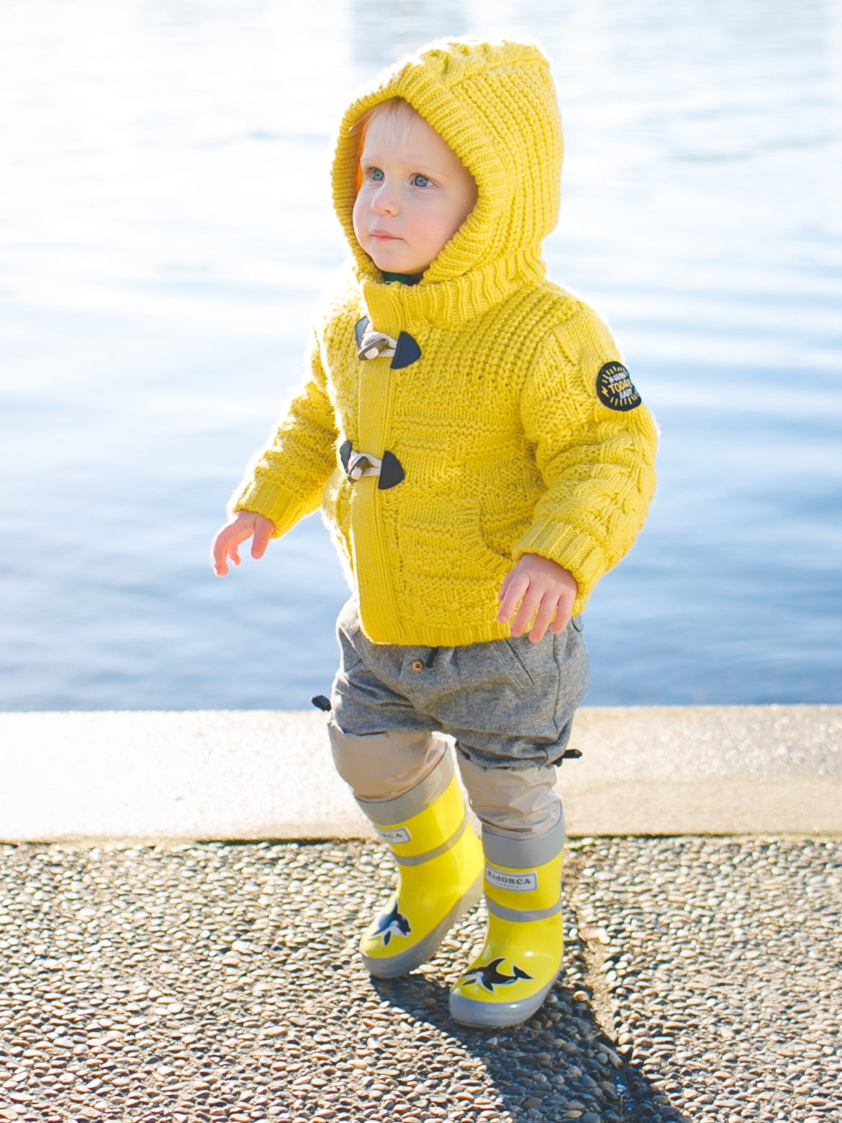 Child wearing yellow above-knee rain waders – side view