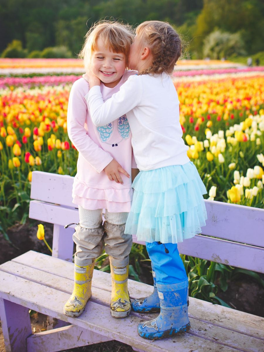 Child wearing blue above-knee rain waders – side view