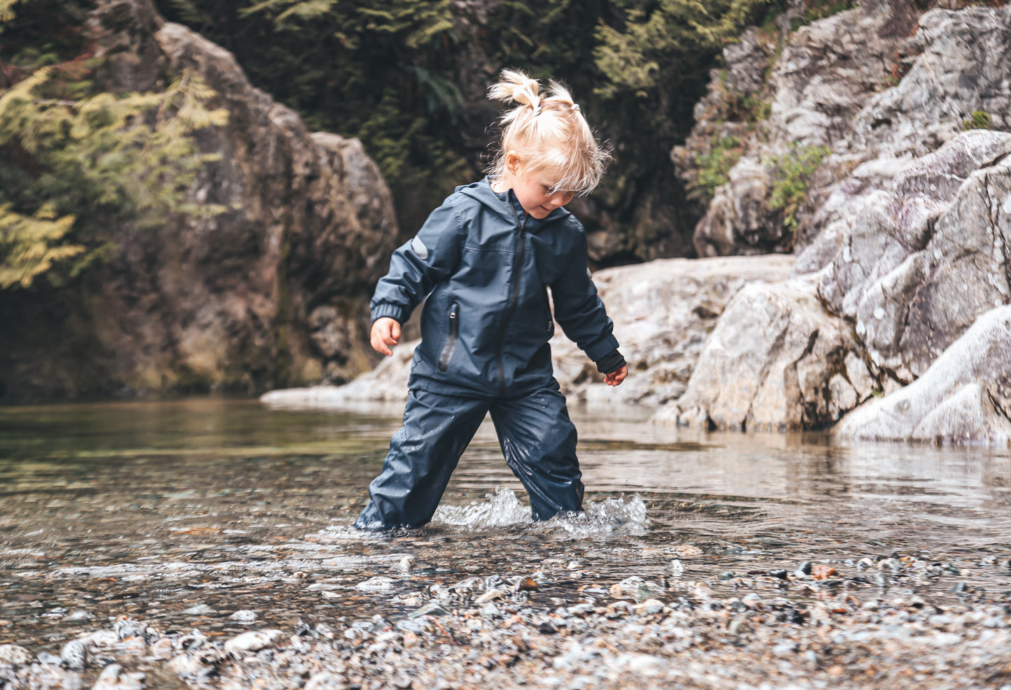 Child wearing navy hard-shell rain jacket – front view