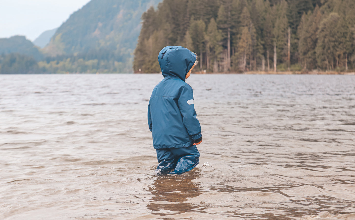 Child wearing navy waterproof rain pants by KidORCA