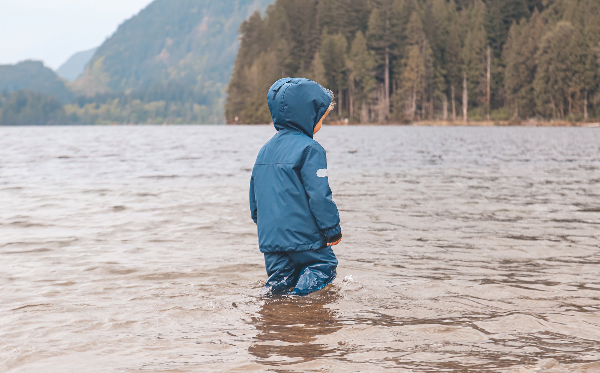 Child wearing navy waterproof rain pants by KidORCA