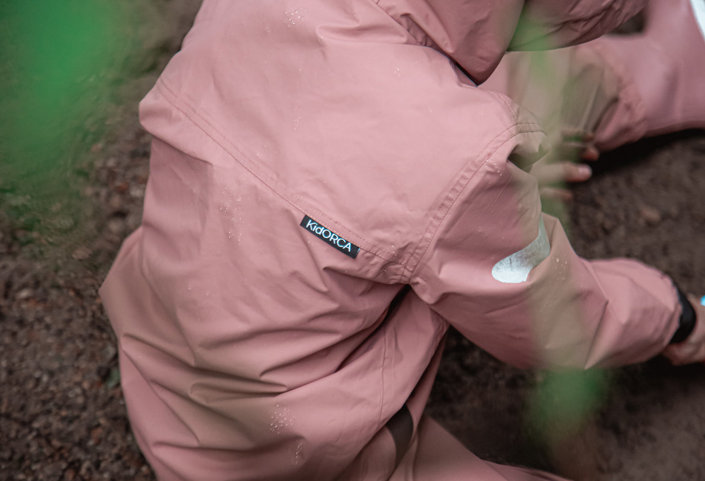 Child wearing ash‑rose hard-shell rain jacket – side view