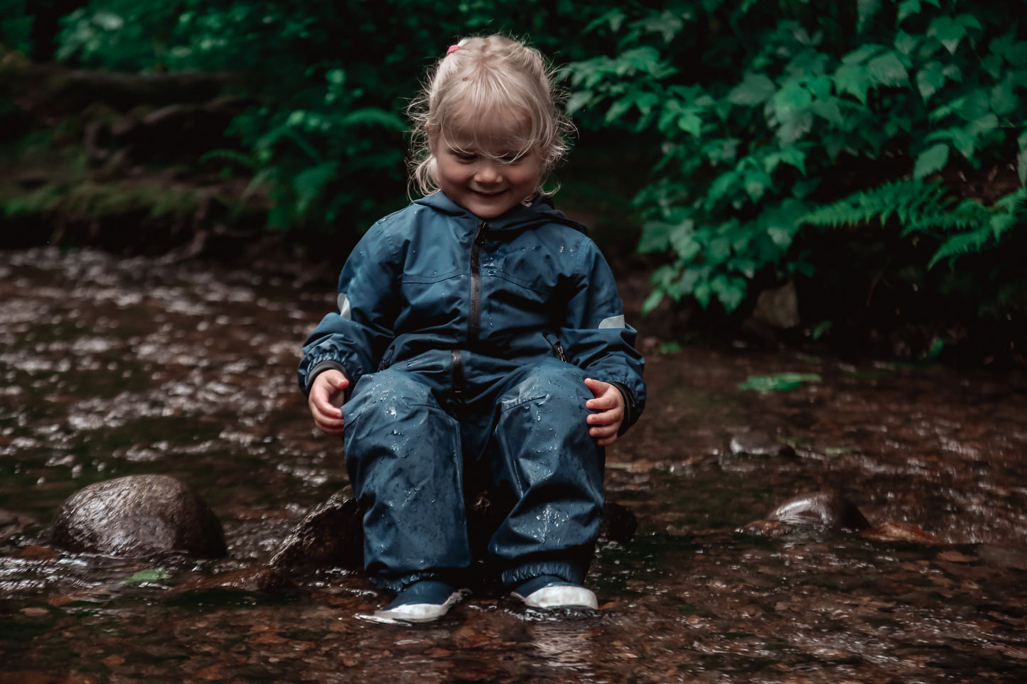 Child wearing navy waterproof rain pants by KidORCA