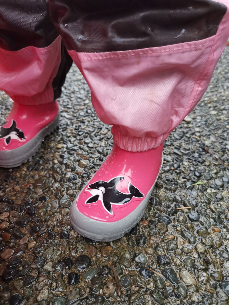 Child splashing in pink rain boots with above-knee waders by KidORCA