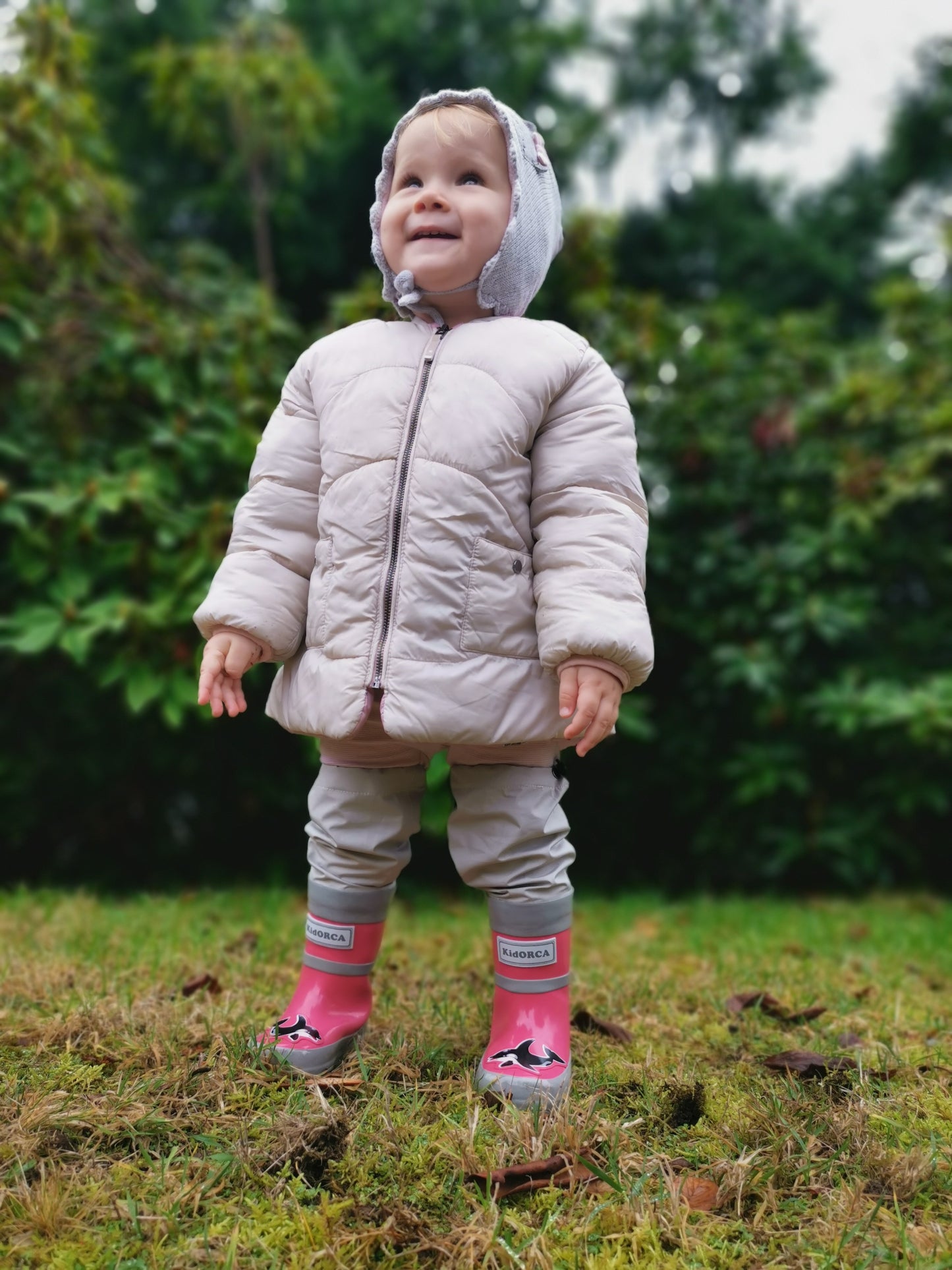 Child wearing pink above-knee rain waders