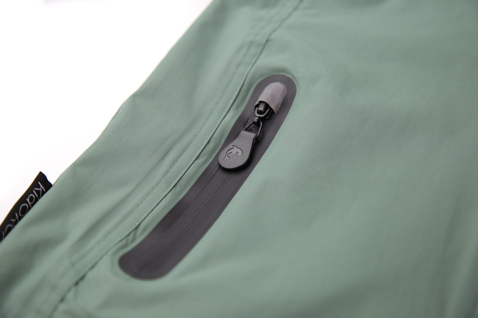 Close-up of waterproof zipper and high collar – olive rain jacket