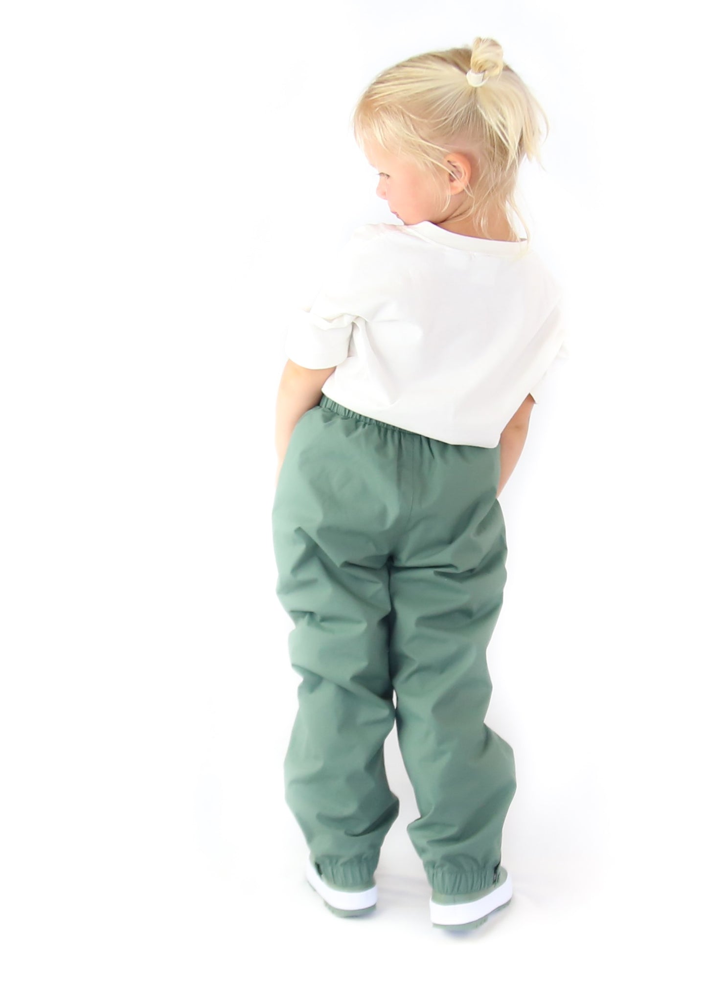 Child wearing olive hard‑shell rain pants by KidORCA