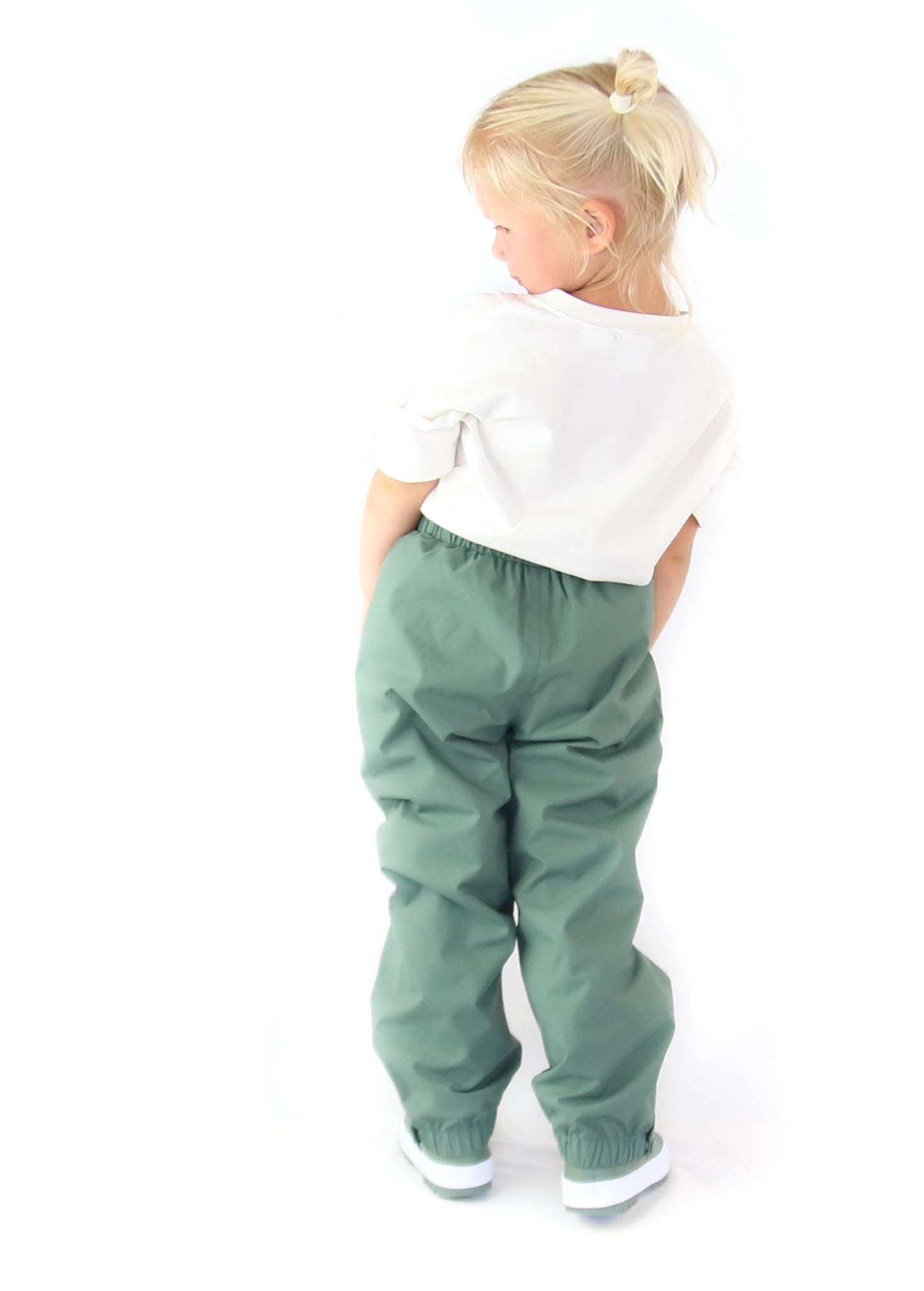 Child wearing olive hard‑shell rain pants by KidORCA