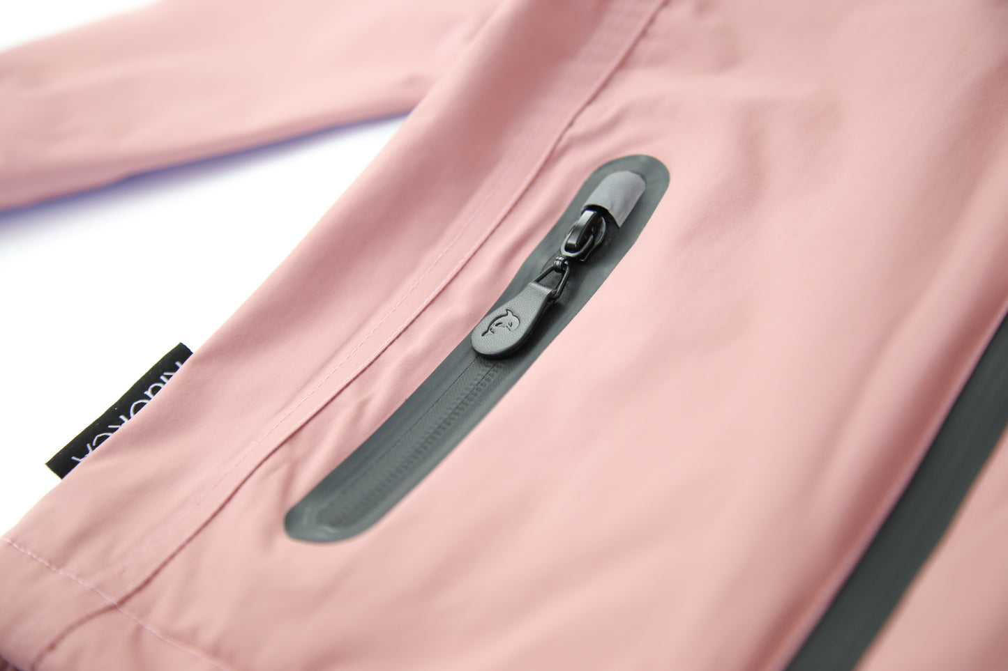 Close-up of waterproof zipper and high collar – ash‑rose rain jacket