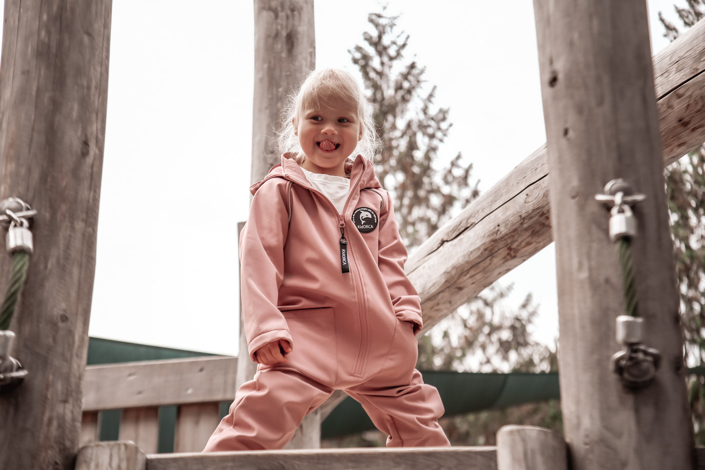 Child wearing ash-rose softshell overall by KidORCA