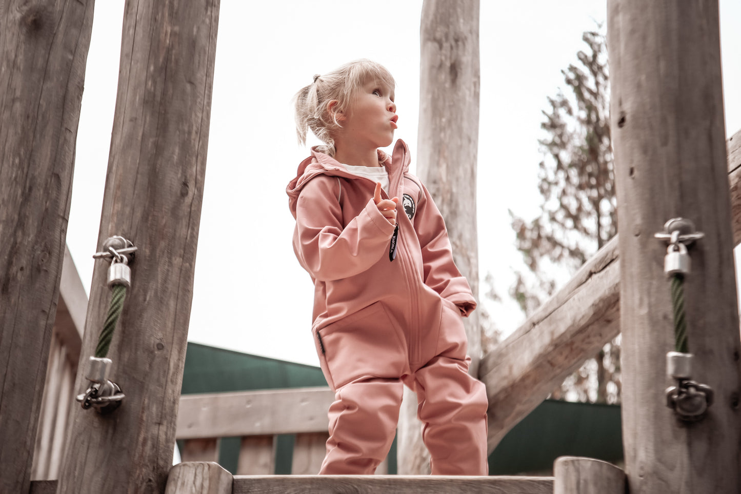 Child wearing ash-rose softshell overall by KidORCA