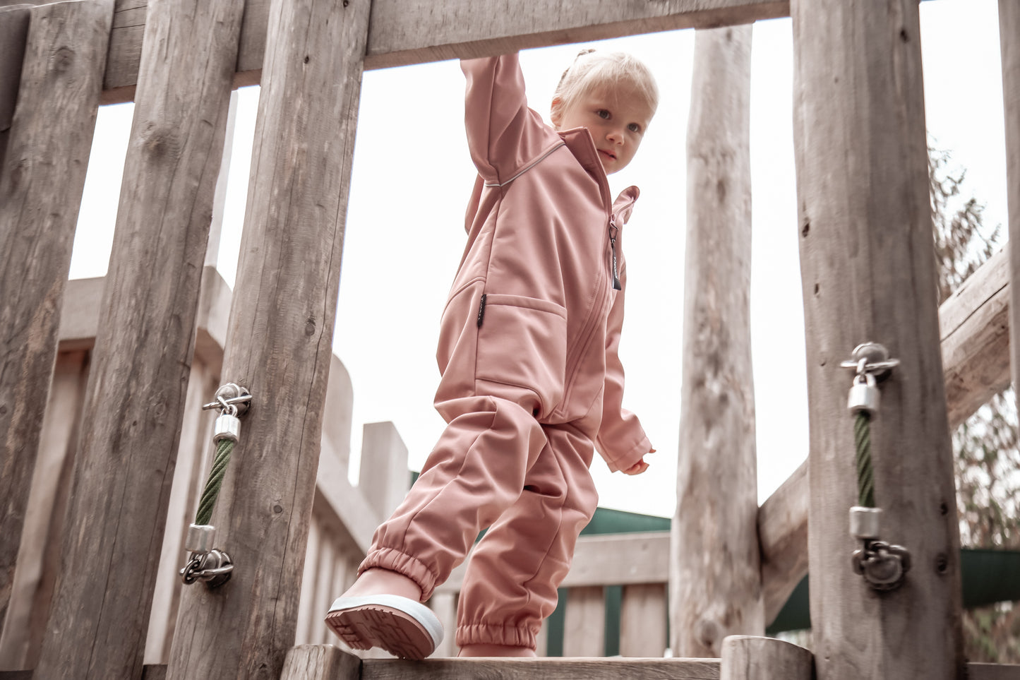 Child wearing ash-rose softshell overall by KidORCA
