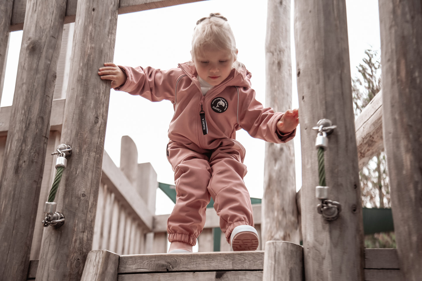 Child wearing ash-rose softshell overall by KidORCA