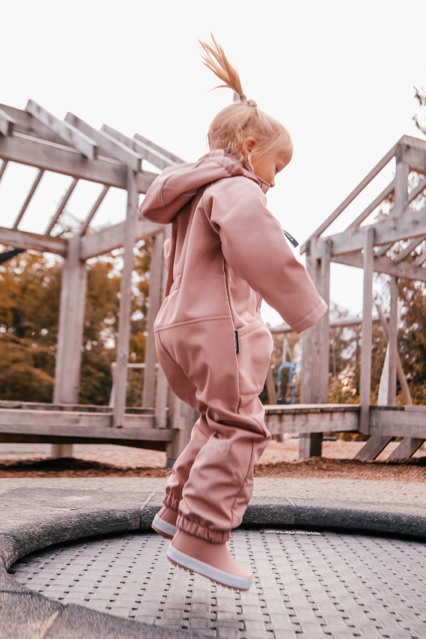 Child wearing ash-rose softshell overall by KidORCA