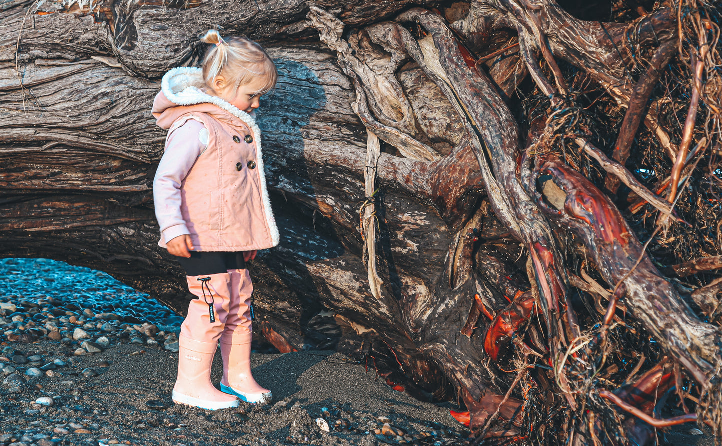 Child splashing in coral rain boots with above-knee waders by KidORCA
