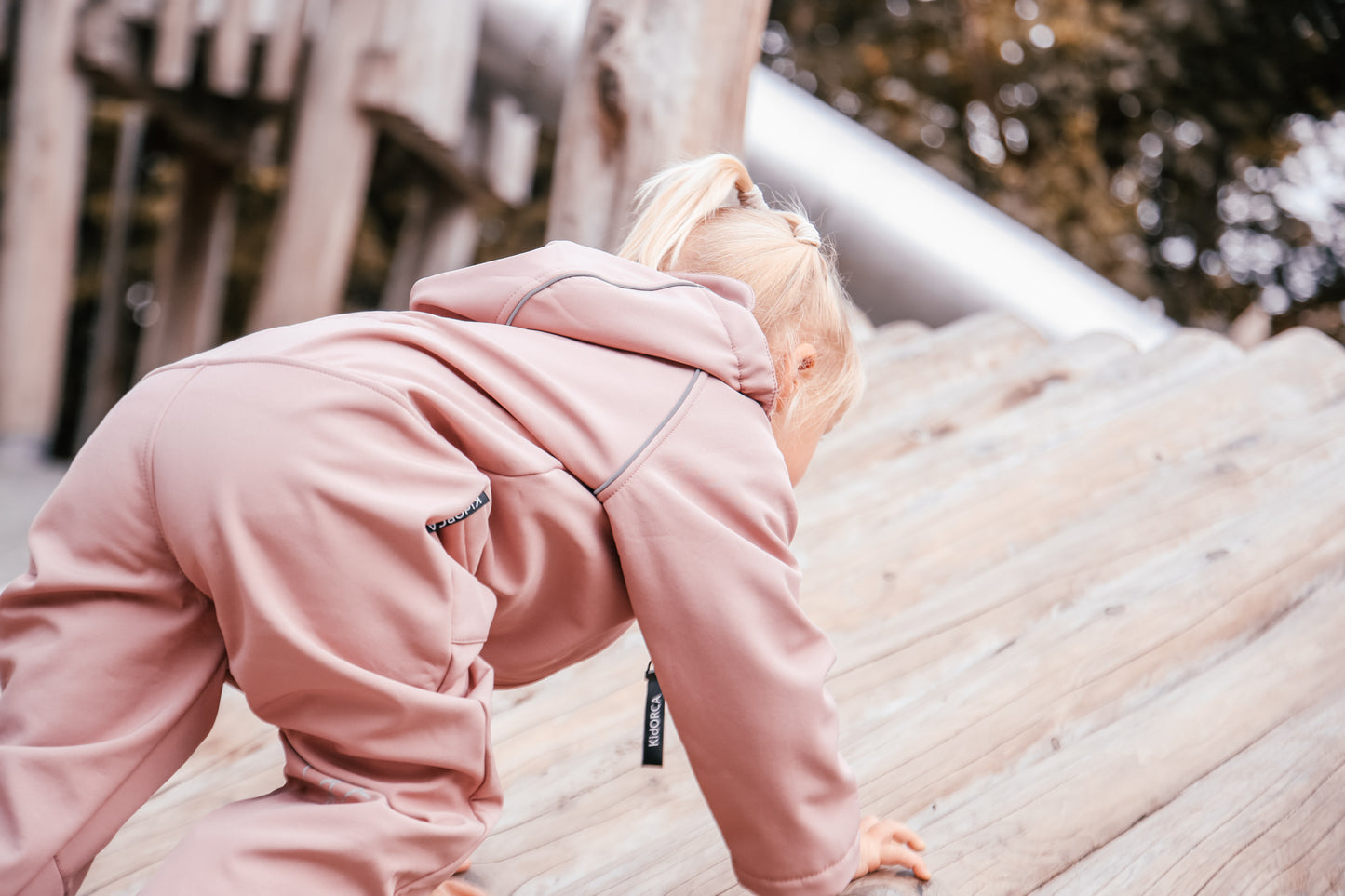 Child wearing ash-rose softshell overall by KidORCA