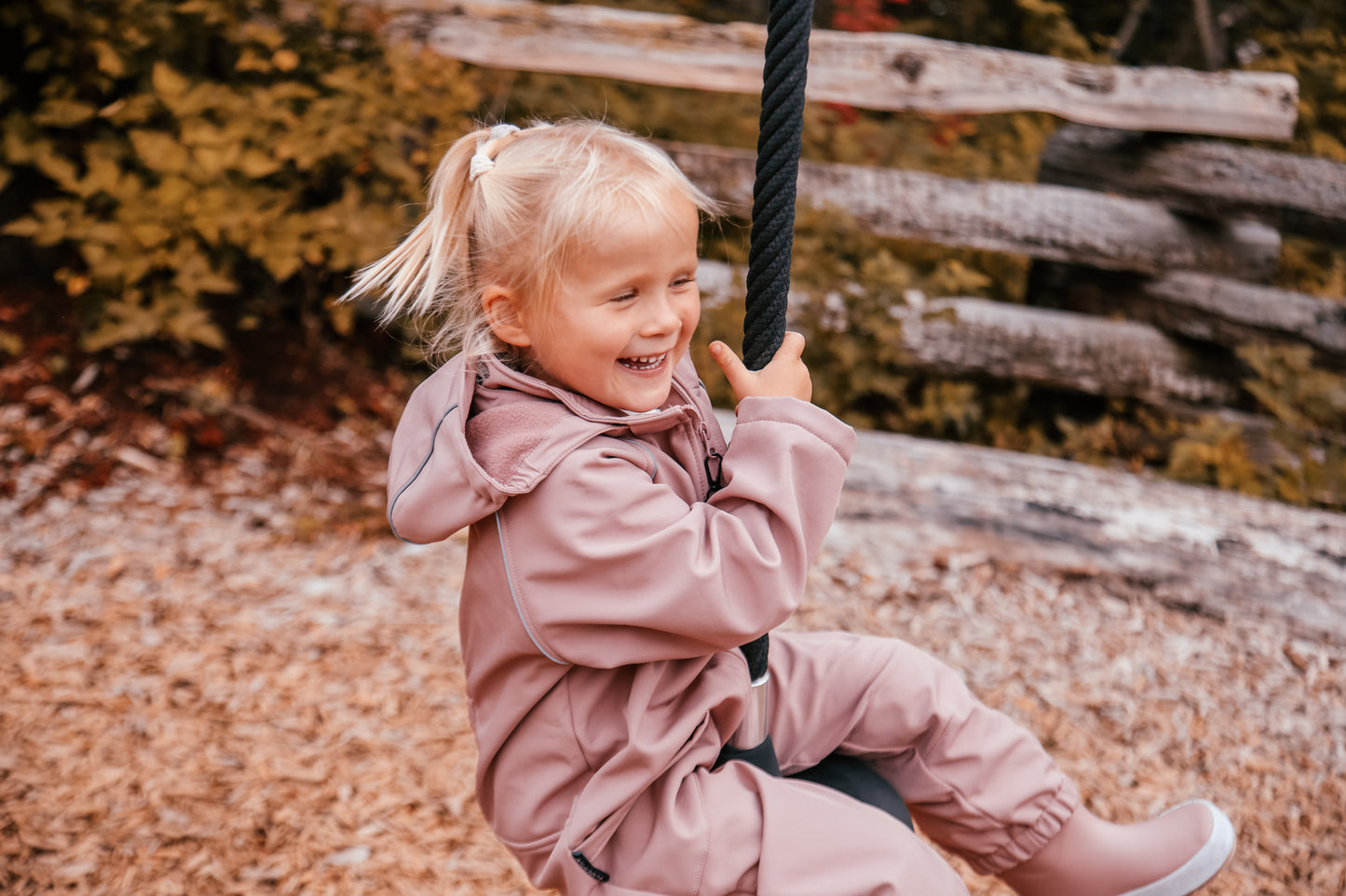Child wearing ash-rose softshell overall by KidORCA