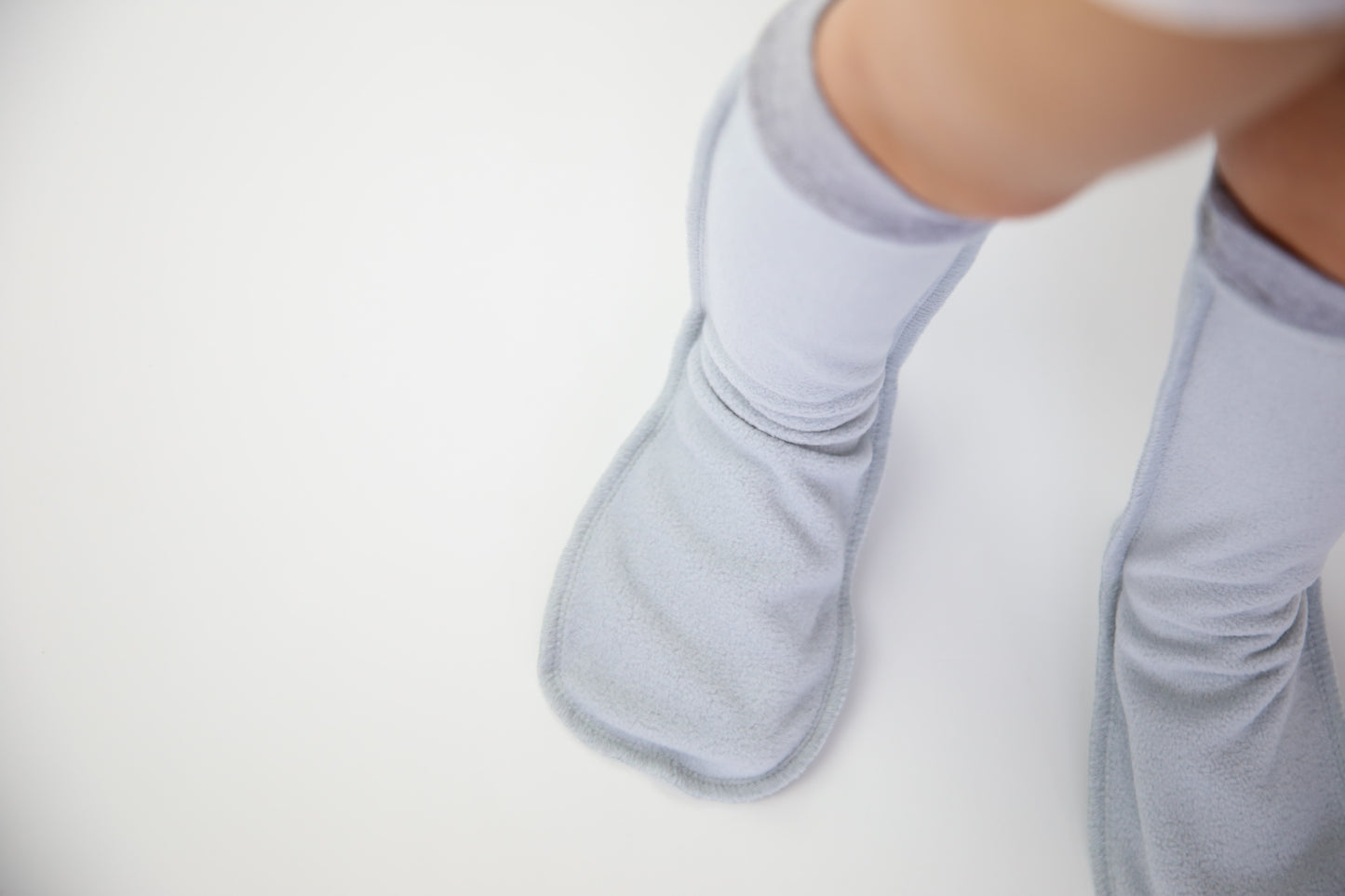 Child wearing grey fleece socks – cozy home comfort