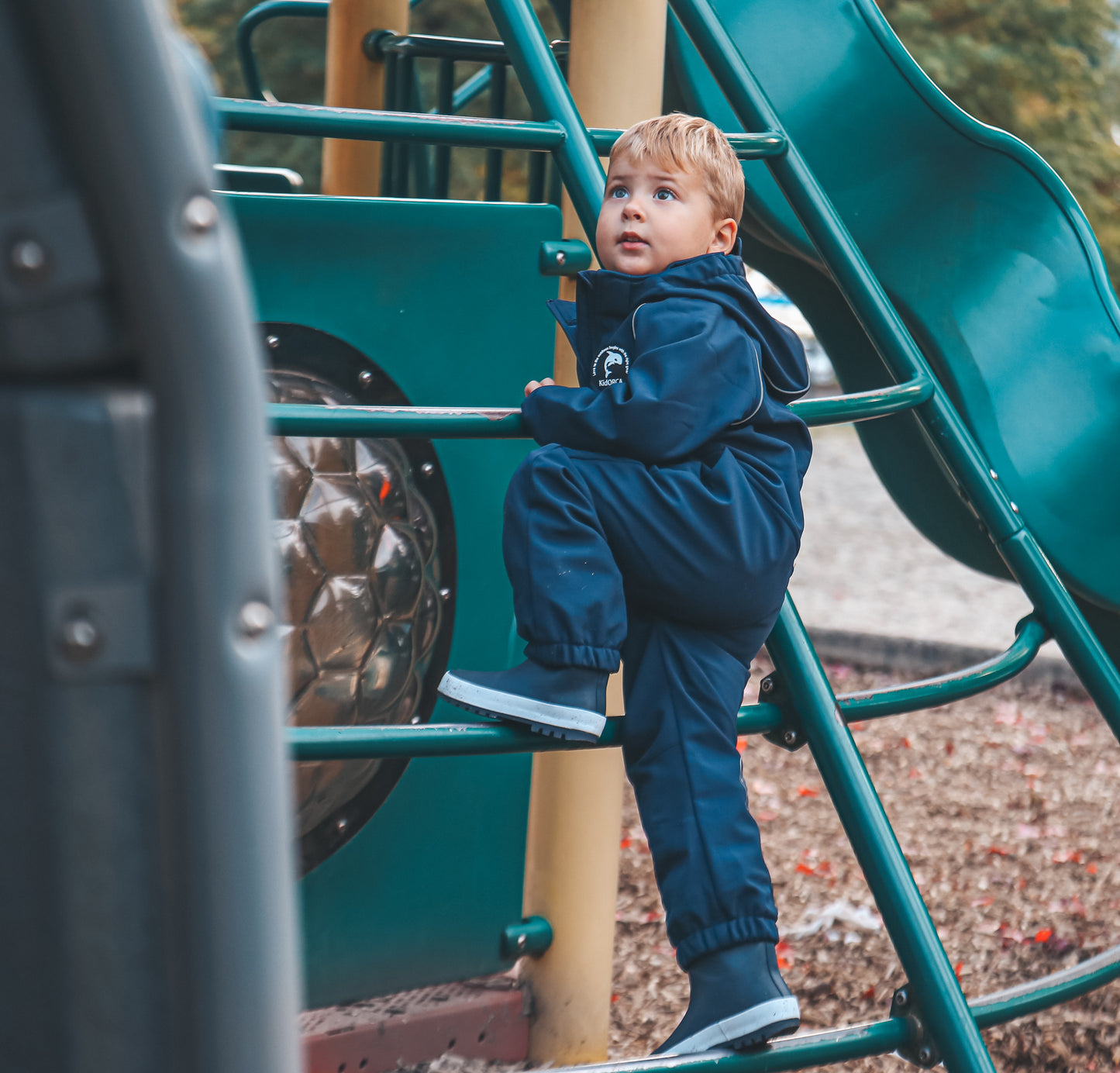 Child wearing navy softshell play suit by KidORCA