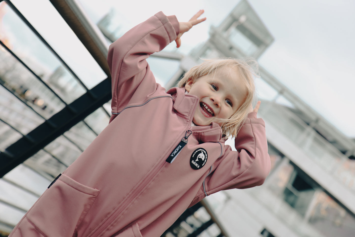 Child wearing ash-rose softshell overall by KidORCA