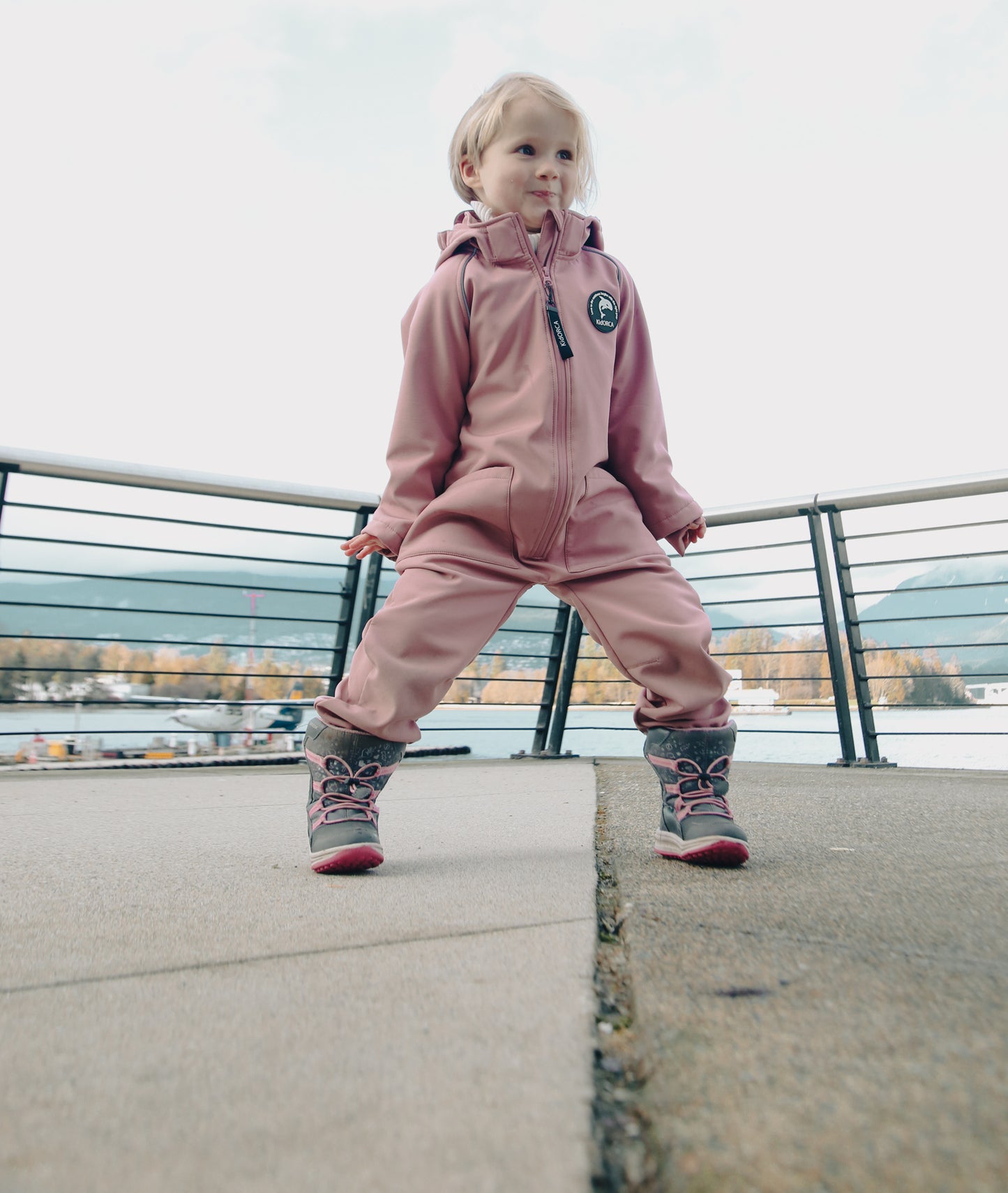 Child wearing ash-rose softshell overall by KidORCA