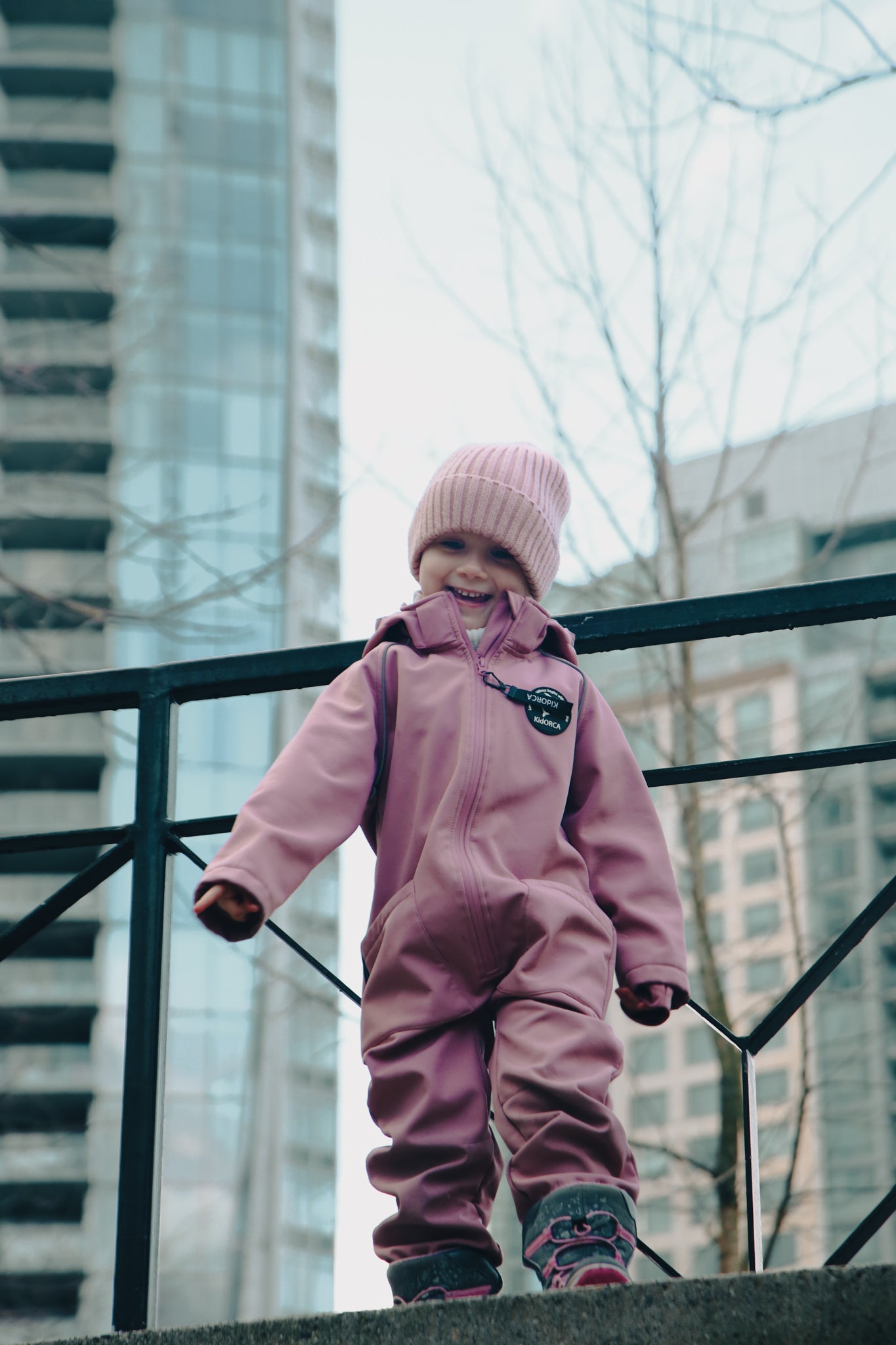 Child wearing ash-rose softshell overall by KidORCA